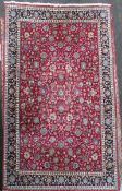 A Meshed carpet, decorated with a field of flowers on a red ground, 16ft 6in. x 11ft 3in.