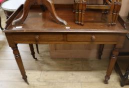 A Victorian mahogany side table having tray top over two short drawers on turned legs with brass