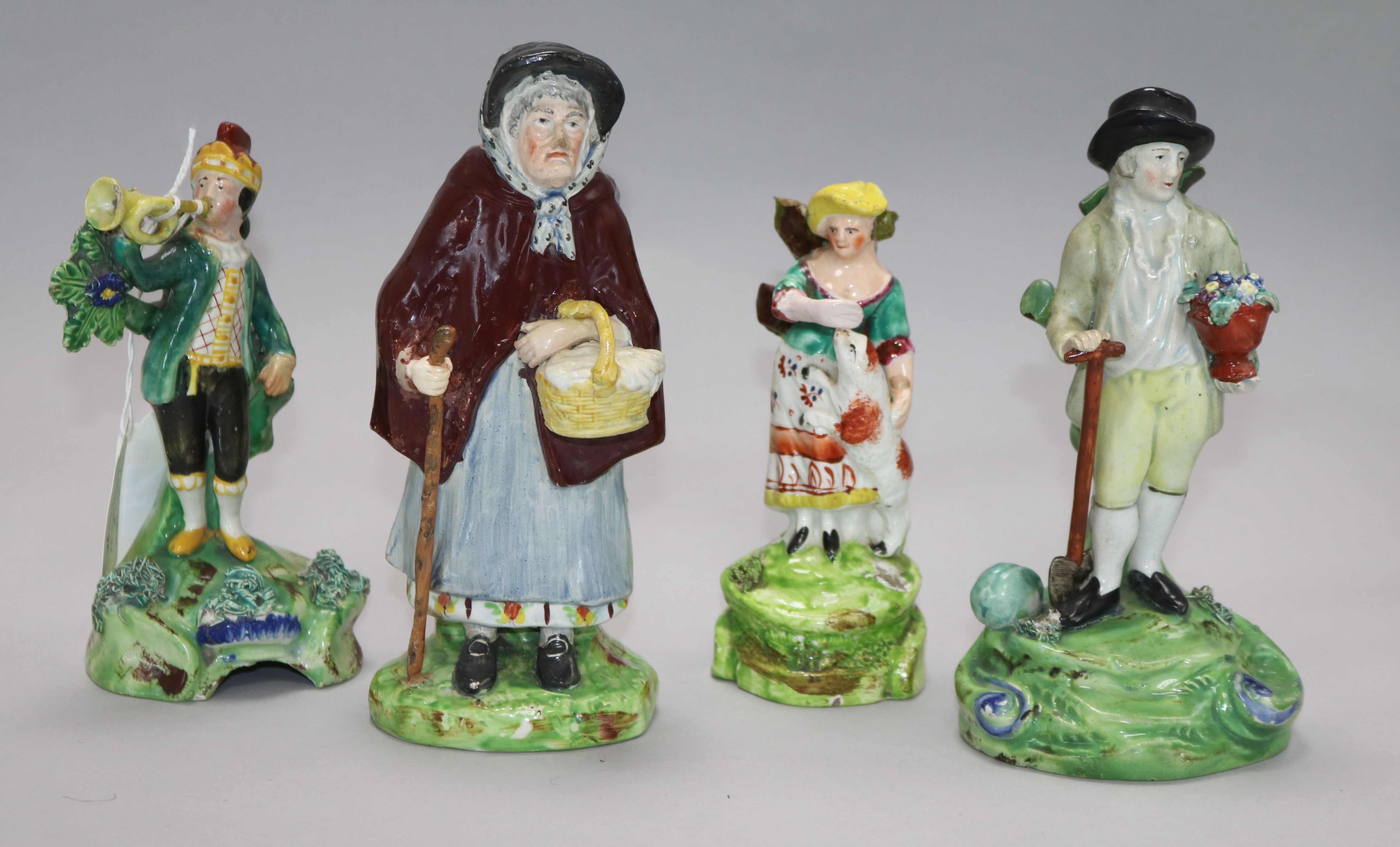 A Staffordshire figure of a gardener by Walton. And three other figures. Height: 16cm