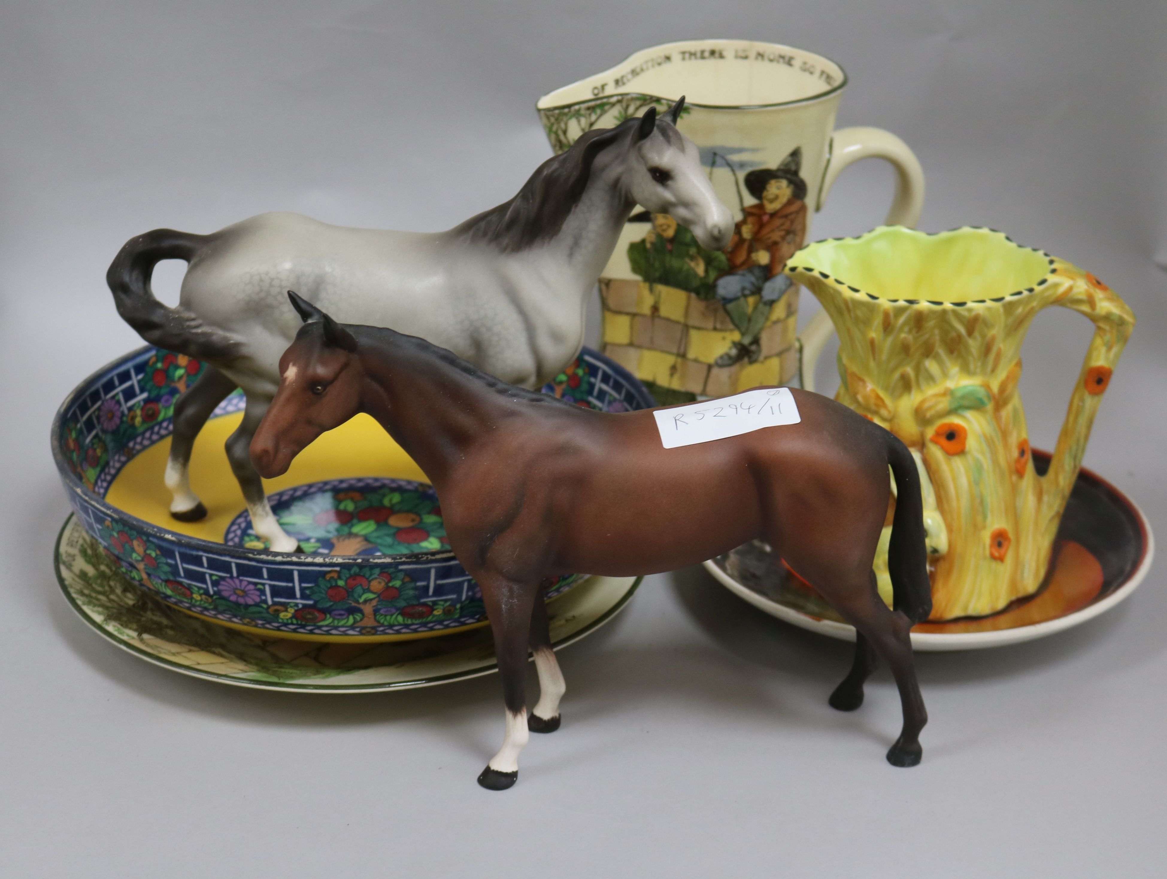 A group of assorted ceramics including two Beswick horses, a Doulton anglers jug and a Poole dish