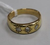 A gentleman's 18ct gold and gypsy set three stone diamond ring, size V.