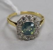 An 18ct gold, diamond and pale blue/green zircon set oval cluster ring, size P.