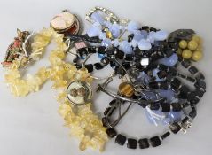 A group of assorted jewellery including tiger's eye quartz necklace and other items.