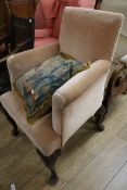 A George II mahogany-framed armchair, covered in gold velvet, on carved cabriole legs and pad feet
