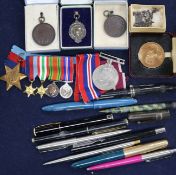 A small box of assorted medallions, pens and medals