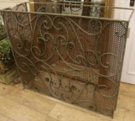 A wrought iron and mesh fire guard W.114cm