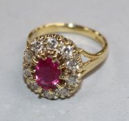 A modern 18ct gold, ruby and diamond oval cluster ring, size F.