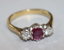 A modern 18ct gold and three stone ruby and diamond ring, size N.