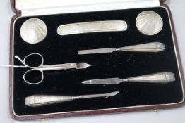 An Adie Bros engine-turned silver manicure set, cased.