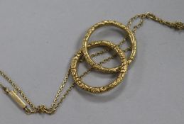 Two chased yellow metal loop rings and a yellow metal fine link chain.