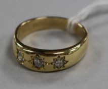 A gentleman's 18ct gold and gypsy set three stone diamond ring, size V.