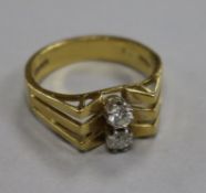 An 18ct gold and two stone diamond dress ring, size O.From the estate of the late Sheila