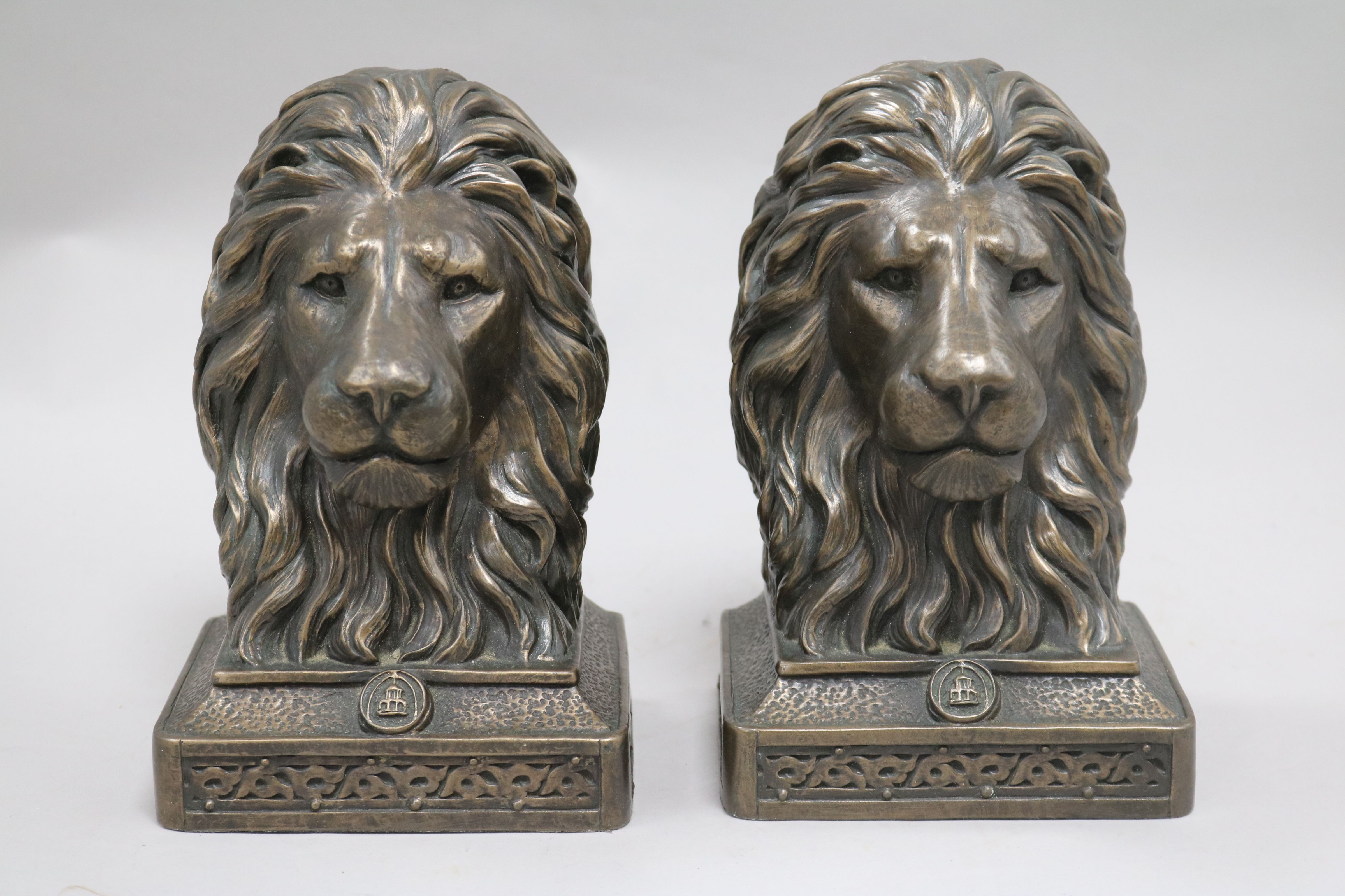 A bronzed resin horse and two lion bookends height 19cmFrom the estate of the late Sheila