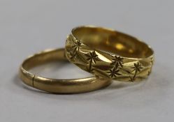 A chased 18ct gold band and a yellow metal band.