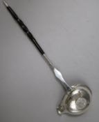 An 18ct century silver toddy ladle with baleen handle and bowl with inset coin, 31.7cm.