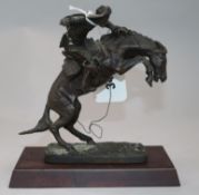 A Franklin Mint bronzed figure, The Broncho Buster, after Frederic Remington 17cm.