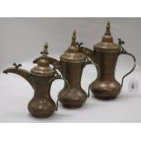 A set of three Bahrain brass and copper dallah coffee pots with old receipt from 1984 largest 28cm