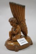 A 19th century quill or spill holder, carved with winged amorini 19cm.