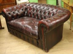 A buttoned burgundy leather two seater Chesterfield settee, W.5ft 5in. D.3ft H.2ft 3in.