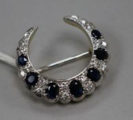 A modern 18ct gold, sapphire and diamond set crescent brooch, 28mm.