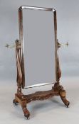 A Regency mahogany cheval mirror, with arched plate and brass candle sconces, W.2ft 7in. H.5ft 4in.
