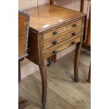 A Regency mahogany drop-flap work table, ebony line-inlaid, fitted three drawers, raised on sabre