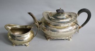 An Edwardian silver teapot and cream jug, gross 25 oz.