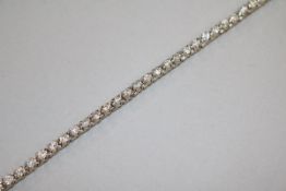 A modern 18ct white gold and diamond line bracelet, set with forty six round cut stones with an