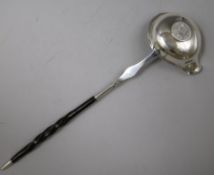 An 18ct century silver toddy ladle with baleen handle and bowl with inset coin, 31.7cm.