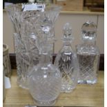 A tall heavy cut glass vase, three decanters and a claret jug