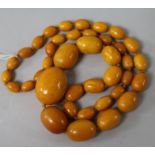 A single strand graduated oval amber bead necklace, gross weight 88 grams, 74cm.