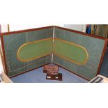An old racing game with board together with lead horses, jockeys and fencing