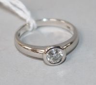 A modern 18ct white gold and solitaire collet set diamond ring, size L.