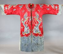 A Chinese embroidered silk 'dragon' robe, woven in metal thread and long threads on a red satin