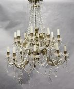 An 18th century style gilt brass and glass sixteen light chandelier, hung with lustre and tear