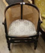 A 1920's caned back tub shaped armchair