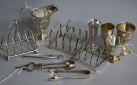 Three silver toast racks, various, a George III style silver helmet cream jug (weighted) and