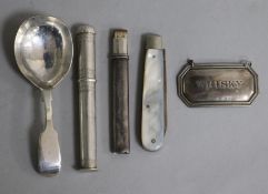 A Victorian silver caddy spoon, a silver whisky label, a Norwegian needlecase, a silver and mop