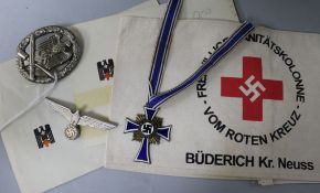 A German Red Cross armband and paperwork, a mothers cross, a general assault badge