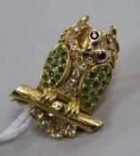 A yellow metal and gem set novelty brooch modelled as an owl perched on a branch with moving eyes,