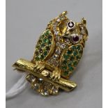 A yellow metal and gem set novelty brooch modelled as an owl perched on a branch with moving eyes,