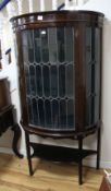 A 1920's mahogany bow fronted display cabinet, enclosed by a glazed leaded door 99cm.