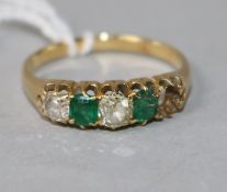 An early 20th century yellow metal and four (ex 5) stone diamond and green doublet half hoop ring,