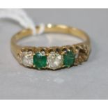 An early 20th century yellow metal and four (ex 5) stone diamond and green doublet half hoop ring,