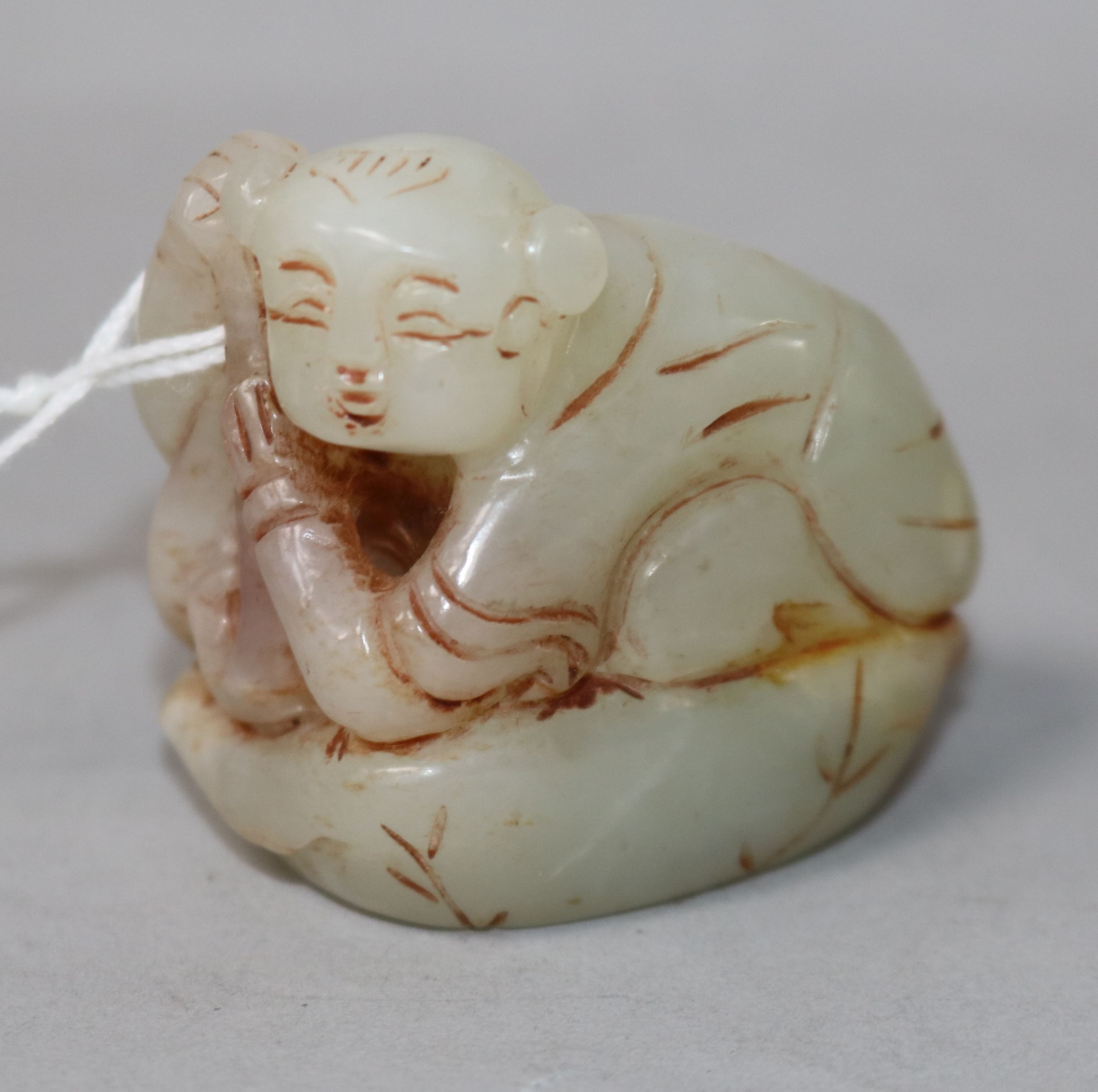 A Chinese jade figure of a crouching boy 4.5cm.