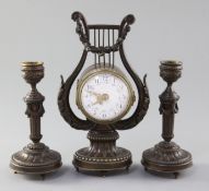 An early 20th century French patinated bronze garniture, the timepiece in lyre case, with 2.25