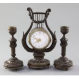 An early 20th century French patinated bronze garniture, the timepiece in lyre case, with 2.25