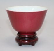 A Chinese ruby ground cup, wood stand Bowl 6.5cms H