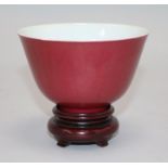 A Chinese ruby ground cup, wood stand Bowl 6.5cms H