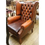 A tan leather buttonback armchair